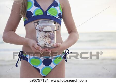 USA, Florida, St. Pete Beach, Girl (8-9) holding jar of seashells on beach, mid section View Large Photo Image Picture - USA, Florida, St. Pete Beach, Girl (8-9) holding jar of seashells on beach, mid section. Fotosearch
