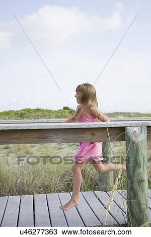 Stock Image - USA, Florida, St. Pete Beach, Girl (8-9) running on boardwalk. Fotosearch