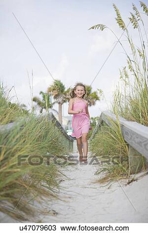 Stock Image - USA, Florida, St. Pete Beach, Girl (8-9) running on beach. Fotosearch