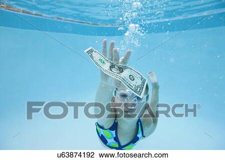 USA, Florida, St. Pete Beach, Girl (8-9) swimming in pool and reaching for one dollar banknote View Large Photo Image Stock Image - USA, Florida, St. Pete Beach, Girl (8-9) swimming in pool and reaching for one dollar banknote. Fotosearch