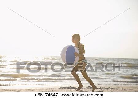 USA, Florida, St. Pete Beach, girl (8-9) running with ball on beach View Large Photo Image Stock Photo - USA, Florida, St. Pete Beach, girl (8-9) running with ball on beach. Fotosearch