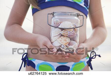 USA, Florida, St. Pete Beach, Girl (8-9) holding jar of seashells on beach, mid section View Large Photo Image Stock Photography - USA, Florida, St. Pete Beach, Girl (8-9) holding jar of seashells on beach, mid section. Fotosearch