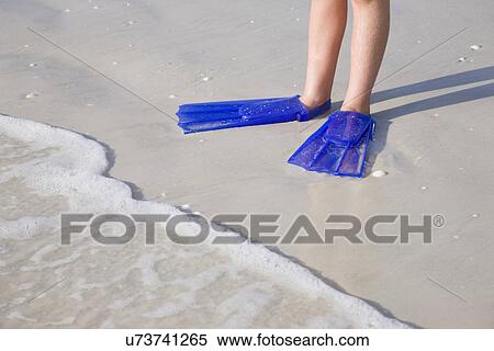 USA, Florida, St. Pete Beach, Girl (8-9) with flippers standing on beach, low section View Large Photo Image Stock Photography - USA, Florida, St. Pete Beach, Girl (8-9) with flippers standing on beach, low section. Fotosearch