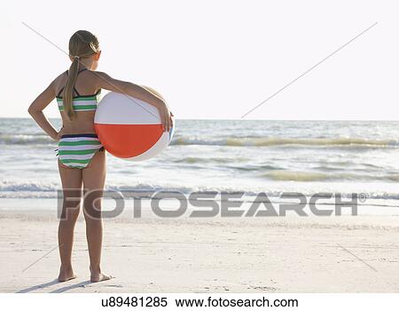 USA, Florida, St. Pete Beach, girl (8-9) standing with ball on beach View Large Photo Image Stock Photography - USA, Florida, St. Pete Beach, girl (8-9) standing with ball on beach. Fotosearch