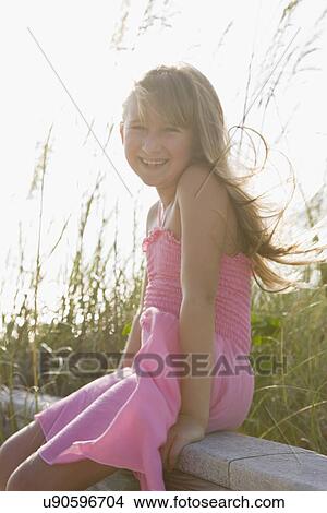 USA, Florida, St. Pete Beach, Portrait of girl (8-9) sitting on wooden rail on beach View Large Photo Image Picture - USA, Florida, St. Pete Beach, Portrait of girl (8-9) sitting on wooden rail on beach. Fotosearch