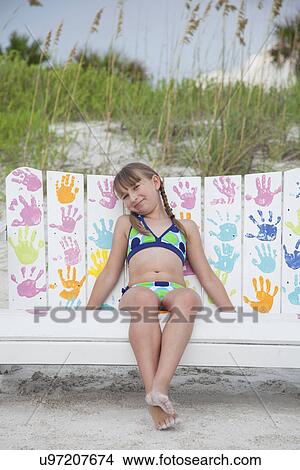 USA, Florida, St. Pete Beach, Portrait of smiling girl (8-9) sitting on colorful bench on beach View Large Photo Image Picture - USA, Florida, St. Pete Beach, Portrait of smiling girl (8-9) sitting on colorful bench on beach. Fotosearch