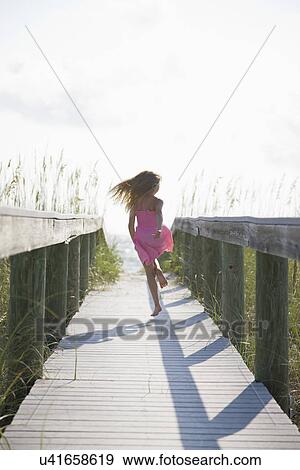 USA, Florida, St. Pete Beach, Rear view of girl (8-9) running on boardwalk View Large Photo Image Stock Photo - USA, Florida, St. Pete Beach, Rear view of girl (8-9) running on boardwalk. Fotosearch