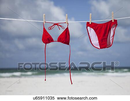 Stock Photography - USA, Florida, St. Pete Beach, Red bikini hanging on clothesline on beach. Fotosearch