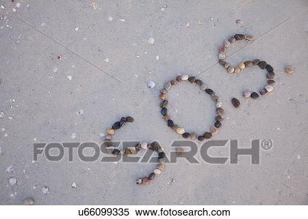 Stock Photography - USA, Florida, St. Pete Beach, SOS writing in pebbles on sand. Fotosearch