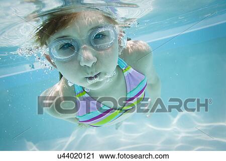 Stock Image - USA Florida, St. Pete Beach, Underwater shot of girl (8-9) diving. Fotosearch