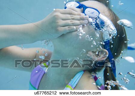 Stock Image - USA Florida, St. Pete Beach, Underwater shot of girl (8-9) diving. Fotosearch
