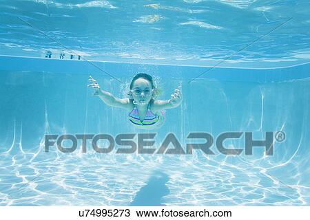 Stock Image - USA Florida, St. Pete Beach, Underwater shot of girl (8-9) diving. Fotosearch
