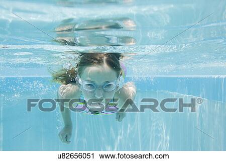 Stock Image - USA Florida, St. Pete Beach, Underwater shot of girl (8-9) diving. Fotosearch