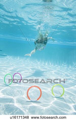 USA Florida, St. Pete Beach, Underwater shot of girl (8-9) diving in swimming pool, colorful circles on floor in foreground View Large Photo Image Stock Photo - USA Florida, St. Pete Beach, Underwater shot of girl (8-9) diving in swimming pool, colorful circles on floor in foreground. Fotosearch