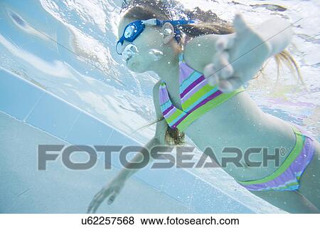 Stock Photo - USA Florida, St. Pete Beach, Underwater shot of girl (8-9) diving. Fotosearch