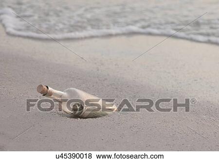 Stock Photo - USA, Florida, St. Petersburg, Bottle with dollar banknote on beach. Fotosearch