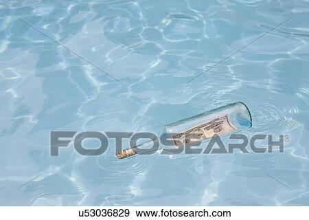USA, Florida, St. Petersburg, Bottle with fifty dollar banknote floating on water View Large Photo Image Stock Photo - USA, Florida, St. Petersburg, Bottle with fifty dollar banknote floating on water. Fotosearch