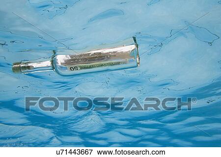 USA, Florida, St. Petersburg, Bottle with fifty dollar banknote floating on water View Large Photo Image Stock Photo - USA, Florida, St. Petersburg, Bottle with fifty dollar banknote floating on water. Fotosearch