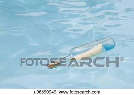 Stock Photo - USA, Florida, St. Petersburg, Bottle with message floating on water. Fotosearch
