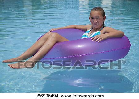 Picture - USA, Florida, St. Petersburg, girl (12-13) floating on water in inflatable tube. Fotosearch