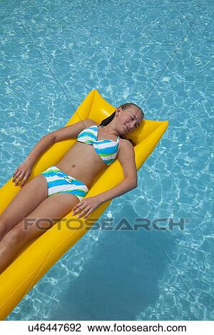 USA, Florida, St. Petersburg, girl (12-13) floating on water in pool raft View Large Photo Image Stock Image - USA, Florida, St. Petersburg, girl (12-13) floating on water in pool raft. Fotosearch