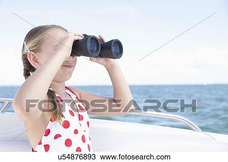 Stock Image - USA, Florida, St. Petersburg, Girl (10-11) on yacht looking through binoculars. Fotosearch