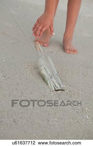 USA, Florida, St. Petersburg, Girl (10-11) reaching for bottle with money on beach, low section View Large Photo Image Stock Image - USA, Florida, St. Petersburg, Girl (10-11) reaching for bottle with money on beach, low section. Fotosearch