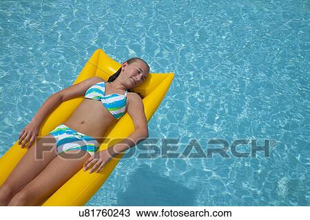 USA, Florida, St. Petersburg, girl (12-13) floating on water in pool raft View Large Photo Image Stock Image - USA, Florida, St. Petersburg, girl (12-13) floating on water in pool raft. Fotosearch