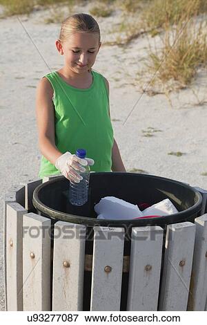Stock Photo - USA, Florida, St. Petersburg, Girl (10-11) cleaning beach. Fotosearch