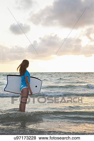 USA, Florida, St. Petersburg, girl (12-13) holding boogie board and looking at view View Large Photo Image Stock Photo - USA, Florida, St. Petersburg, girl (12-13) holding boogie board and looking at view. Fotosearch