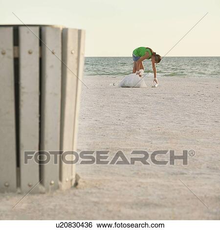 USA, Florida, St. Petersburg, Girl (10-11) cleaning beach, garbage bin in foreground View Large Photo Image Stock Photograph - USA, Florida, St. Petersburg, Girl (10-11) cleaning beach, garbage bin in foreground. Fotosearch