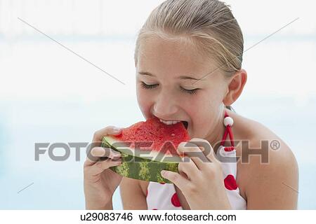 Stock Photograph - USA, Florida, St. Petersburg, Girl (10-11) eating watermelon. Fotosearch