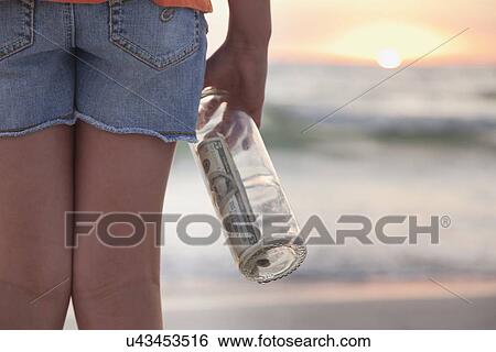 USA, Florida, St. Petersburg, Girl (10-11) holding bottle with money on beach, mid section View Large Photo Image Stock Photograph - USA, Florida, St. Petersburg, Girl (10-11) holding bottle with money on beach, mid section. Fotosearch