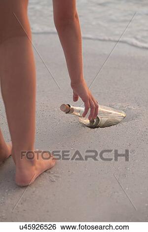 USA, Florida, St. Petersburg, Girl (10-11) reaching for bottle with money on beach, low section View Large Photo Image Stock Photograph - USA, Florida, St. Petersburg, Girl (10-11) reaching for bottle with money on beach, low section. Fotosearch