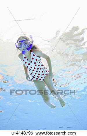 Stock Photography - USA, Florida, St. Petersburg, Girl (10-11) diving in swimming pool. Fotosearch