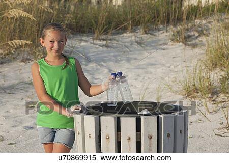 Stock Photography - USA, Florida, St. Petersburg, Girl (10-11) cleaning beach. Fotosearch