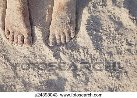 Stock Image - USA, Florida, St. Petersburg, girl's feet (12-13) covered with sand. Fotosearch
