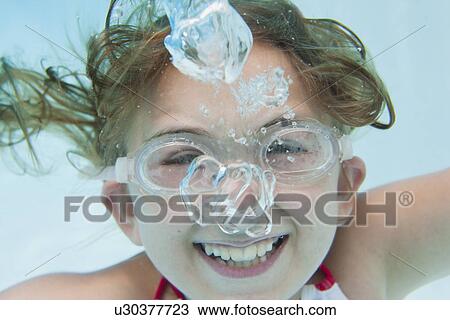 Stock Image - USA, Florida, St. Petersburg, Portrait of girl (10-11) diving in swimming pool. Fotosearch