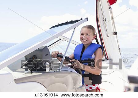 USA, Florida, St. Petersburg, Smilling girl (10-11) wearing life jacket steering speedboat View Large Photo Image Picture - USA, Florida, St. Petersburg, Smilling girl (10-11) wearing life jacket steering speedboat. Fotosearch