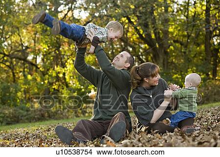 USA, Illinois, Brimfield, Family with two sons (6-11 months, 2-3) playing in Autumn park View Large Photo Image Picture - USA, Illinois, Brimfield, Family with two sons (6-11 months, 2-3) playing in Autumn park. Fotosearch