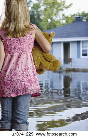 USA, Illinois, Chillicothe, Girl (6-7) standing in water and carrying teddy bear, rear view View Large Photo Image Stock Photo - USA, Illinois, Chillicothe, Girl (6-7) standing in water and carrying teddy bear, rear view. Fotosearch