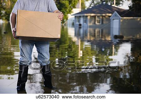 Stock Image - USA, Illinois, Chillicothe, Man holding cardboard box. Fotosearch