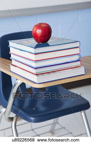 USA, Illinois, Metamora, Apple on stacked books in classroom View Large Photo Image Stock Photo - USA, Illinois, Metamora, Apple on stacked books in classroom. Fotosearch