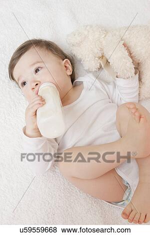 Stock Photo - USA, Illinois, Metamora, baby boy (12-17 months) drinking milk from bottle. Fotosearch