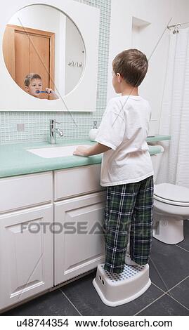 Picture - USA, Illinois, Metamora, Boy (6-7) brushing teeth in bathroom. Fotosearch