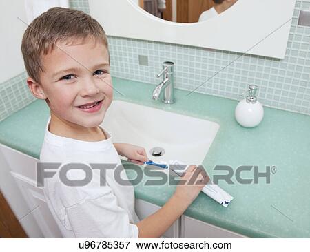 USA, Illinois, Metamora, Boy (6-7) applying toothpaste to toothbrush in bathroom View Large Photo Image Stock Photo - USA, Illinois, Metamora, Boy (6-7) applying toothpaste to toothbrush in bathroom. Fotosearch