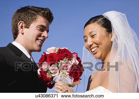 Stock Image - USA, Illinois, Metamora, Bride and groom with flower bouquet. Fotosearch