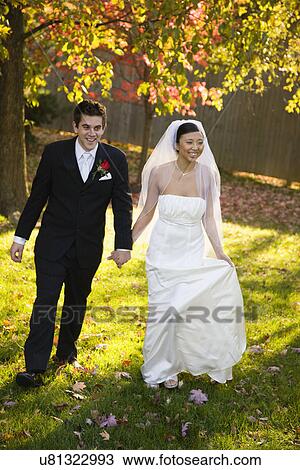 USA, Illinois, Metamora, Bride and groom holding hands View Large Photo Image Stock Image - USA, Illinois, Metamora, Bride and groom holding hands. Fotosearch
