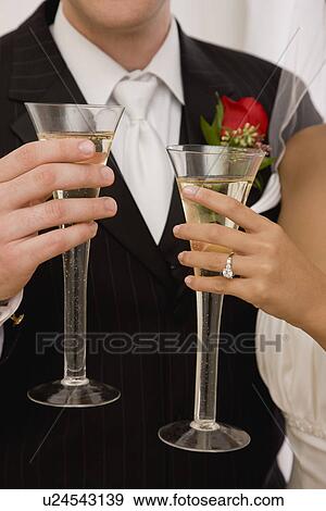 USA, Illinois, Metamora, Bride and groom holding champagne View Large Photo Image Stock Photo - USA, Illinois, Metamora, Bride and groom holding champagne. Fotosearch