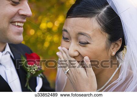 Stock Photo - USA, Illinois, Metamora, Bride and groom laughing. Fotosearch